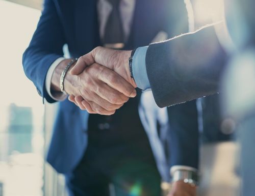 Business professionals shaking hands over a high-value FMCG contract, symbolizing successful deal-making enabled by AI-driven negotiation planning.